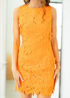 Orange lace dress worn by a person with a blurred background