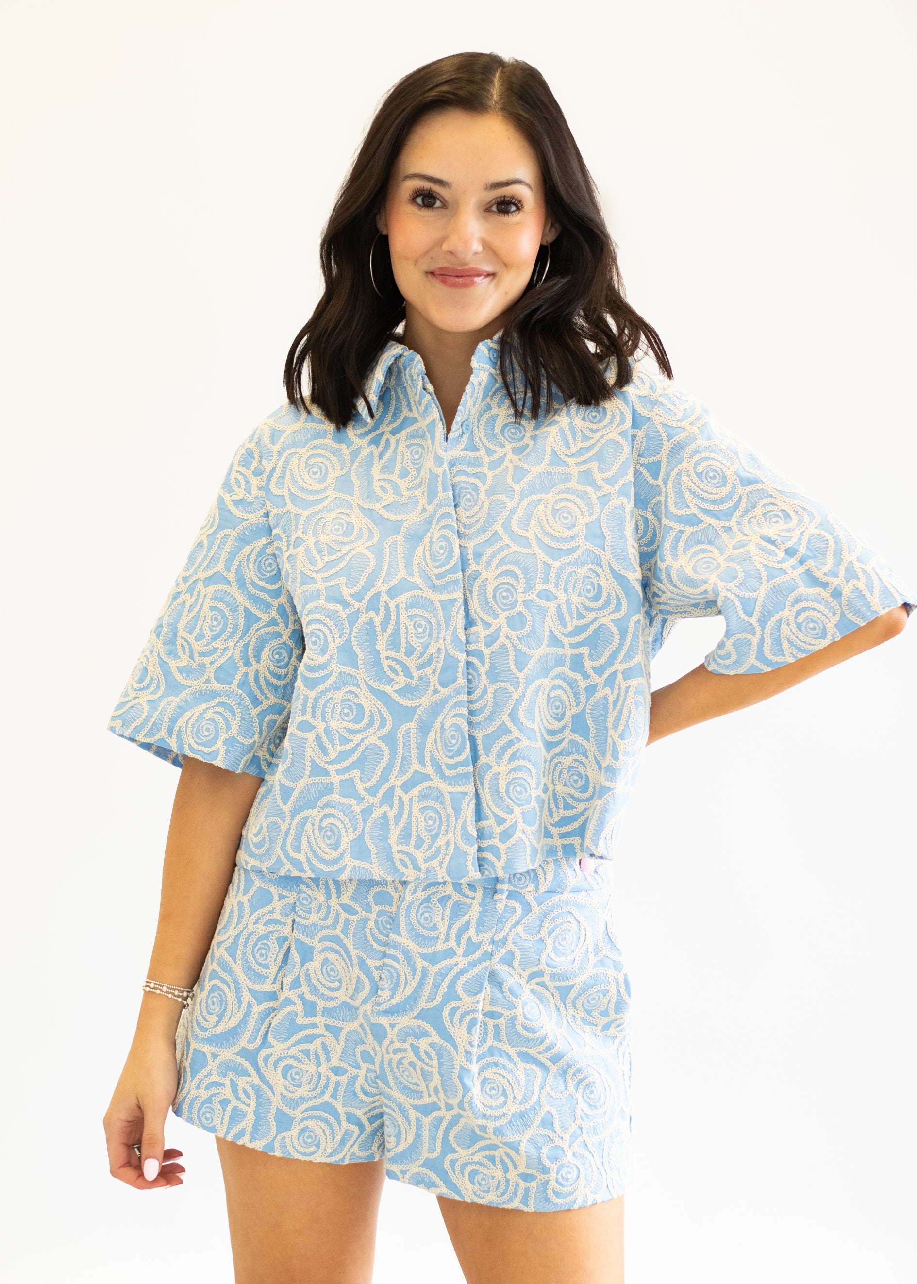 Woman wearing a light blue patterned nightshirt on a white background