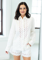 Woman wearing a white outfit with lace details in a bright room