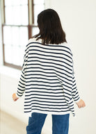 Person wearing a black and white striped sweater in a bright room