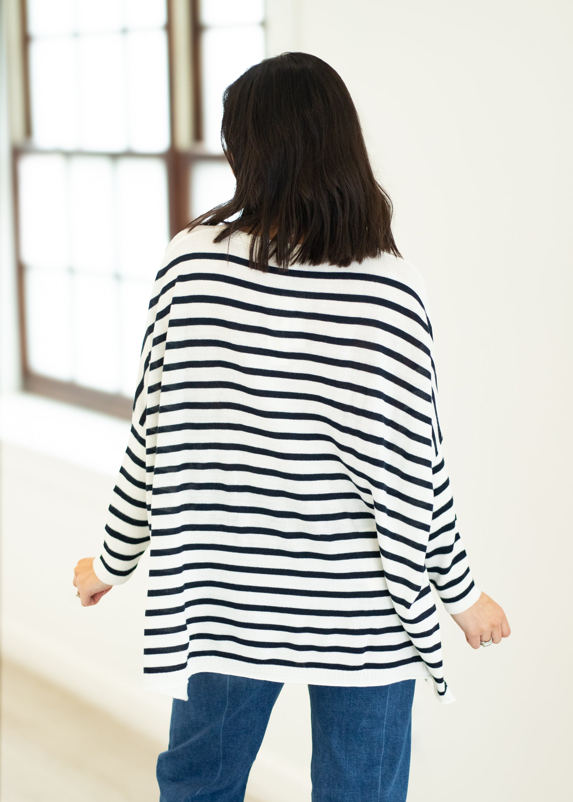 Person wearing a black and white striped sweater in a bright room