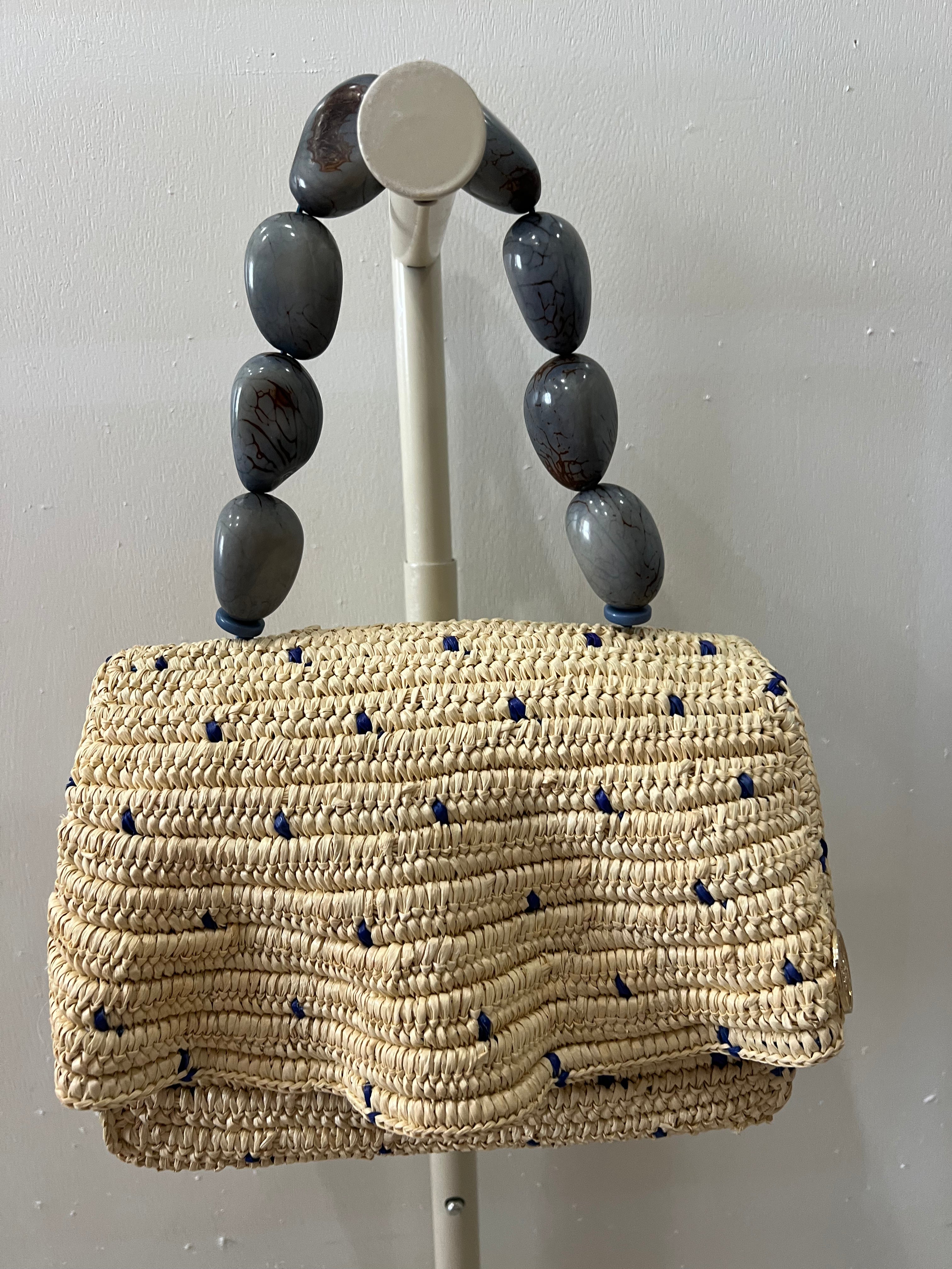 Woven handbag with blue accents on a gray background