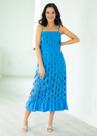 Woman wearing a blue dress with cut-out patterns on a white background