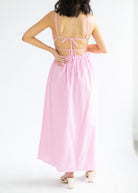 Woman wearing a pink and white striped dress on a white background