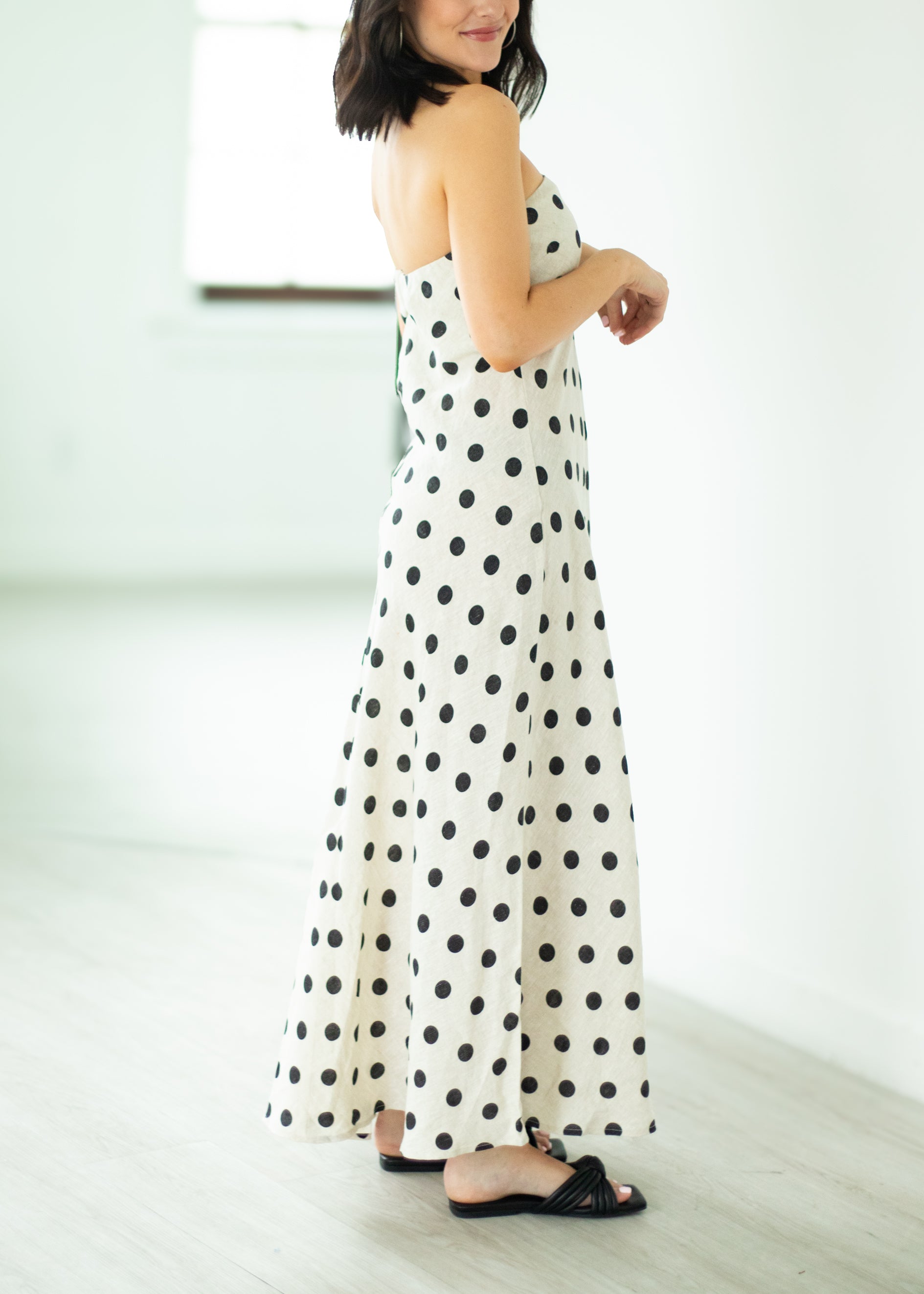 Woman wearing a polka dot dress standing against a white background