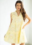 Woman wearing a yellow embroidered dress against a white background