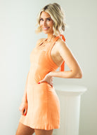 Woman wearing an orange dress against a white background
