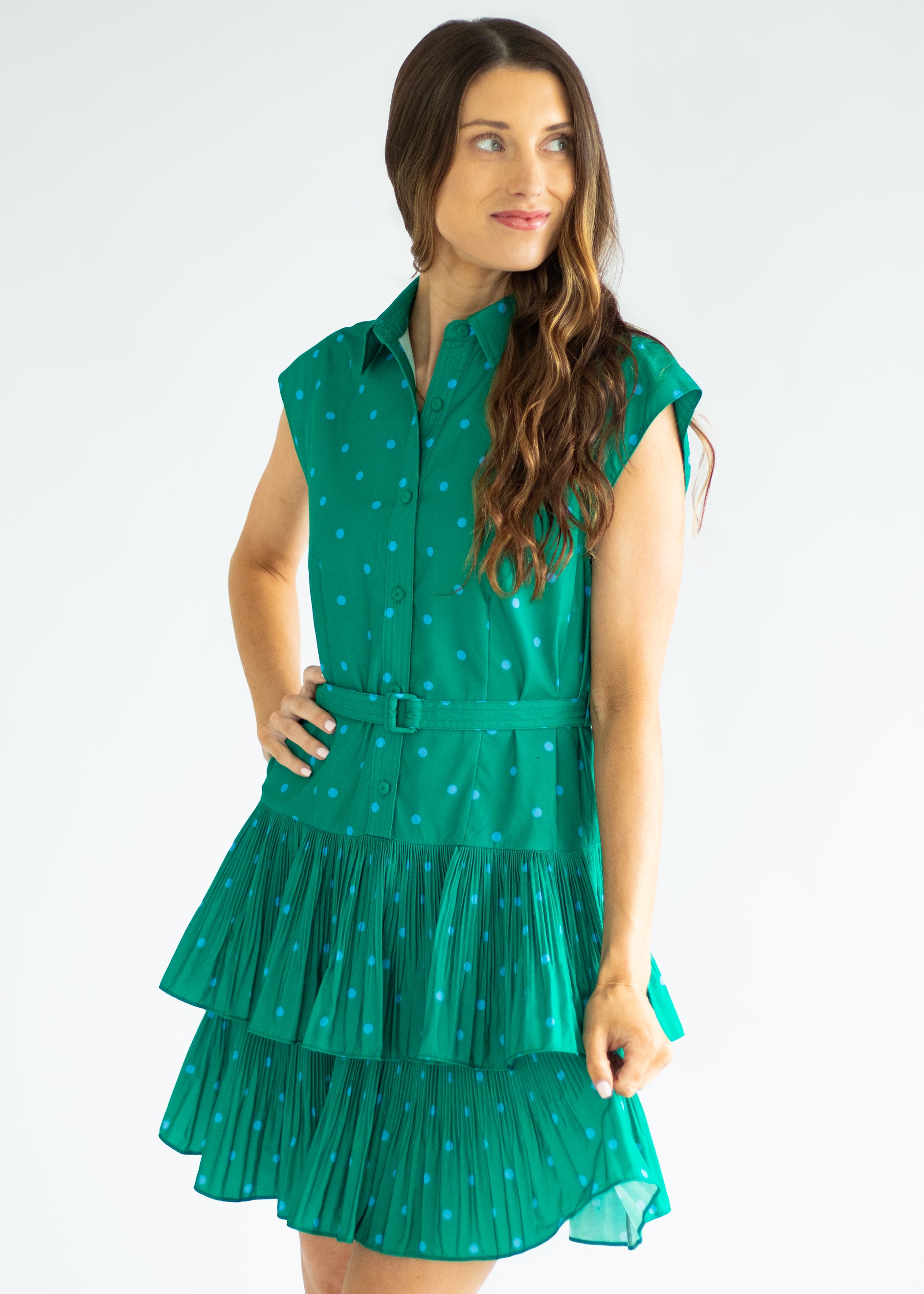 Woman wearing a green polka dot dress on a white background