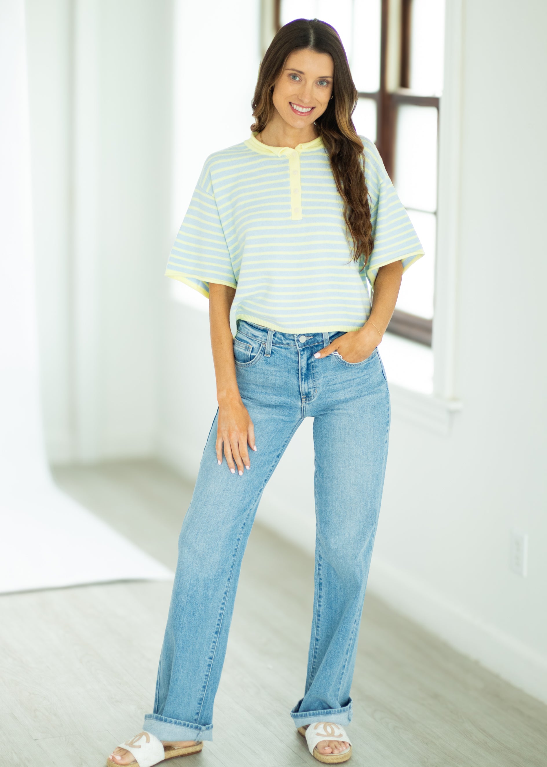 Woman wearing a striped shirt and blue jeans indoors