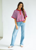 Woman wearing a red and white striped shirt and blue jeans on a white background