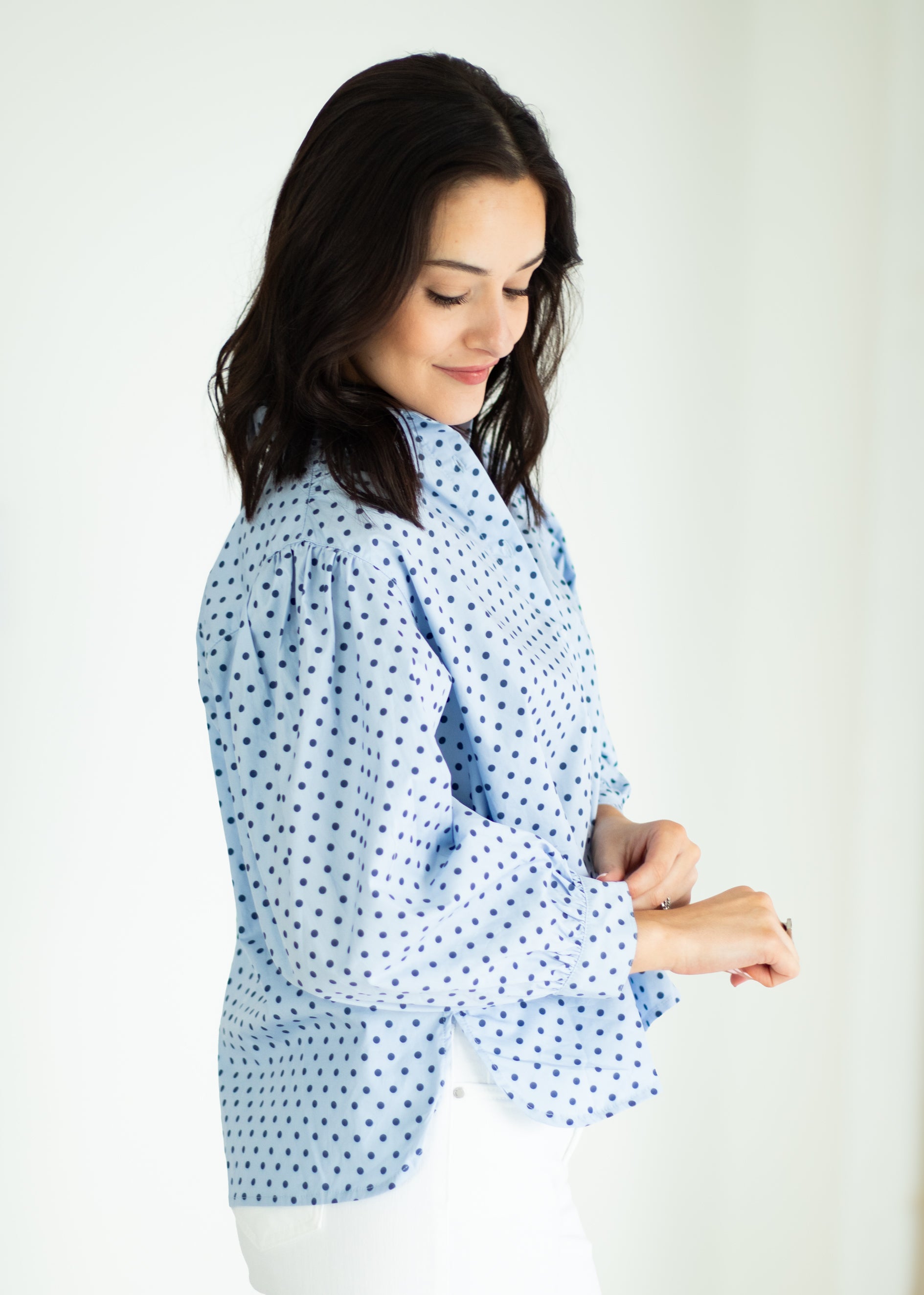 Woman wearing a blue polka dot outfit against a white background