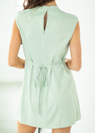Light green romper with a tie waist on a white background