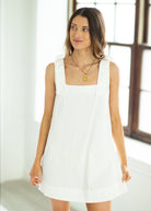 Woman wearing a white dress in a bright room