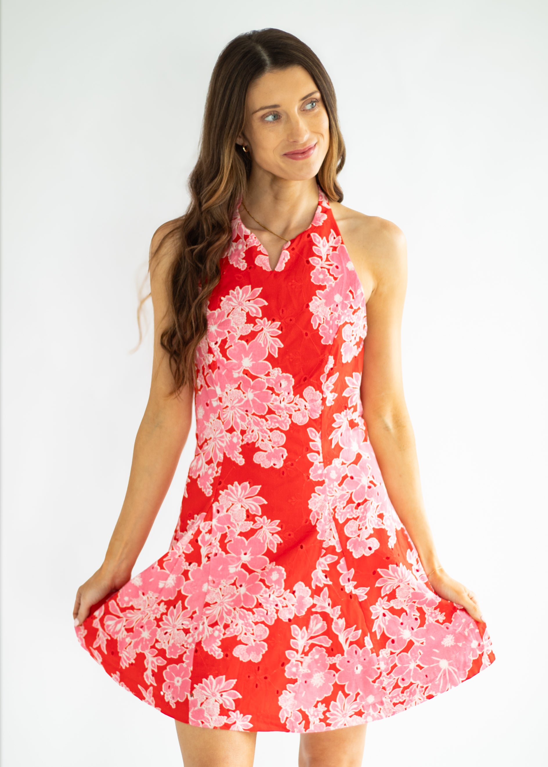 Woman wearing a red floral dress against a white background