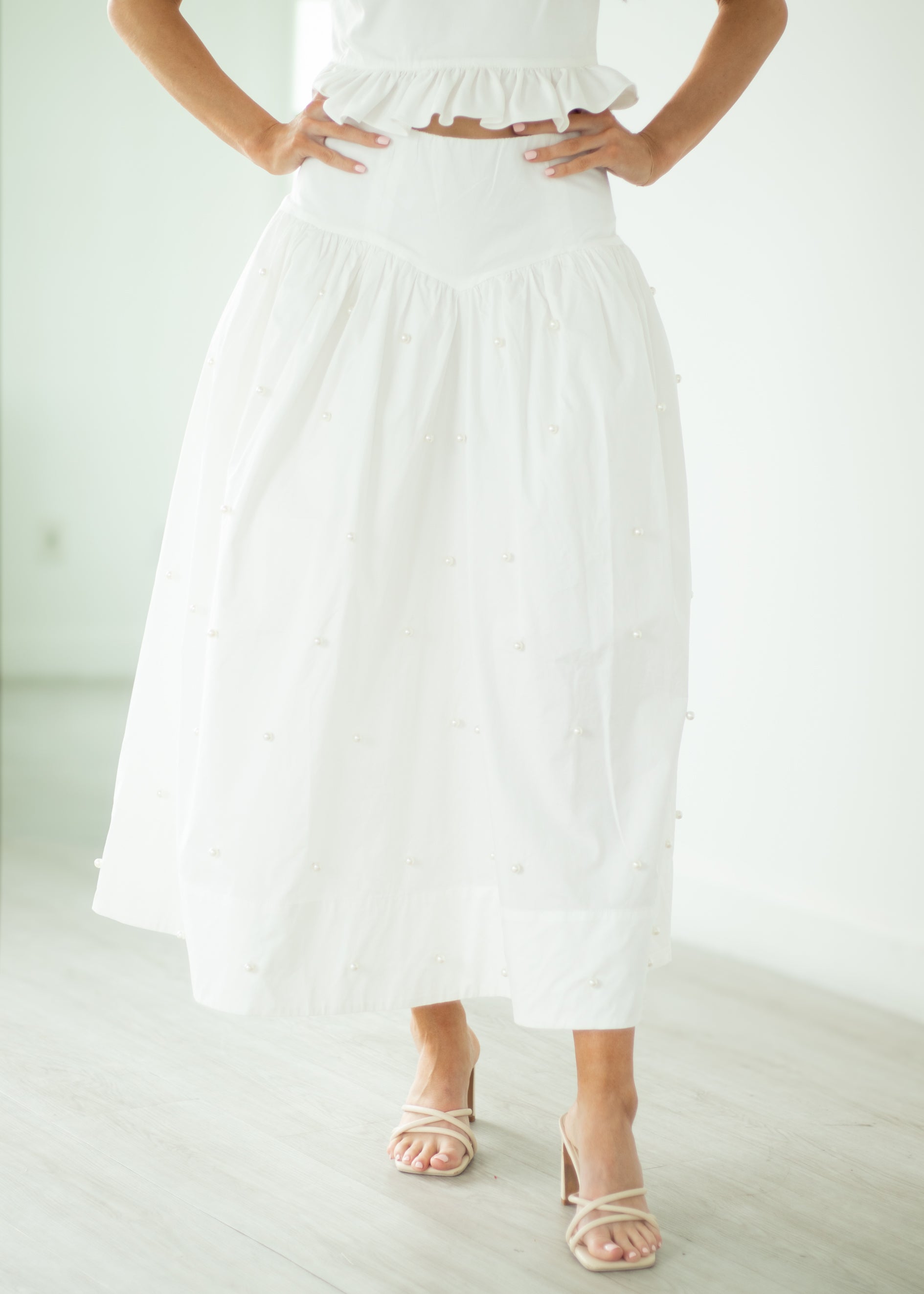 Person wearing a white dress with a plain background