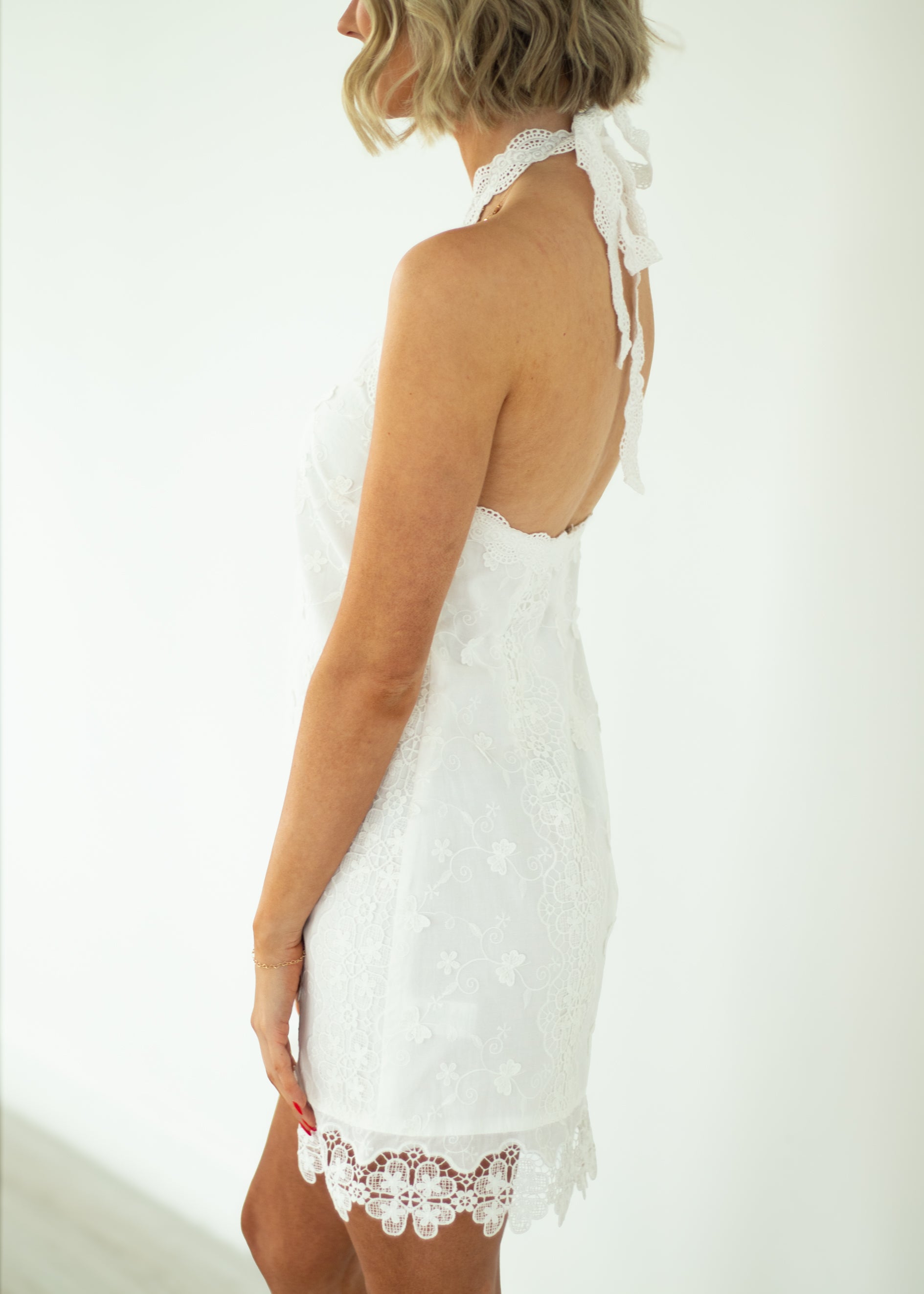 Woman wearing a white lace nightgown against a plain background