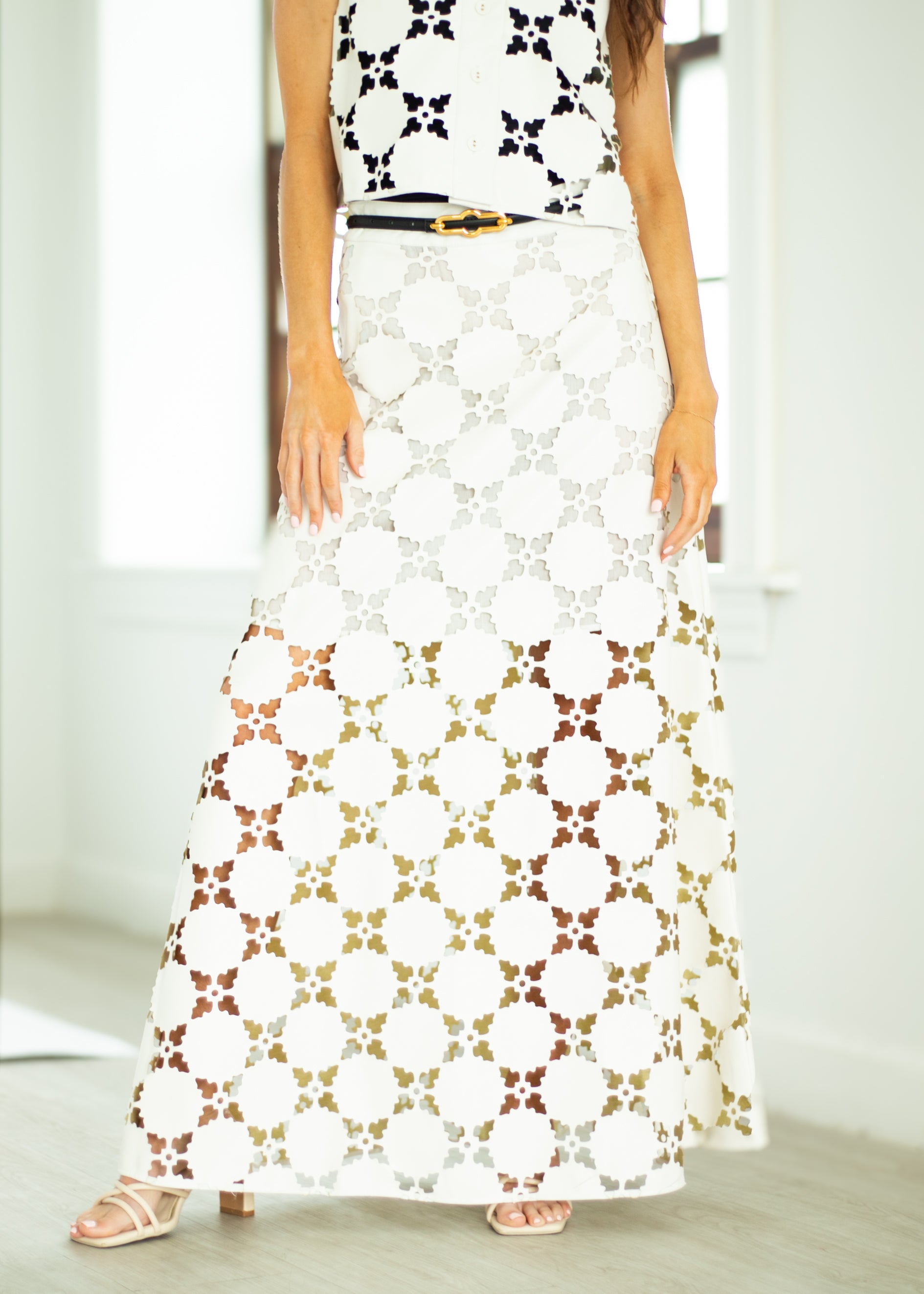 Woman wearing a white floral patterned skirt with a plain background