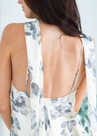 Woman wearing a floral dress with an open back against a white background
