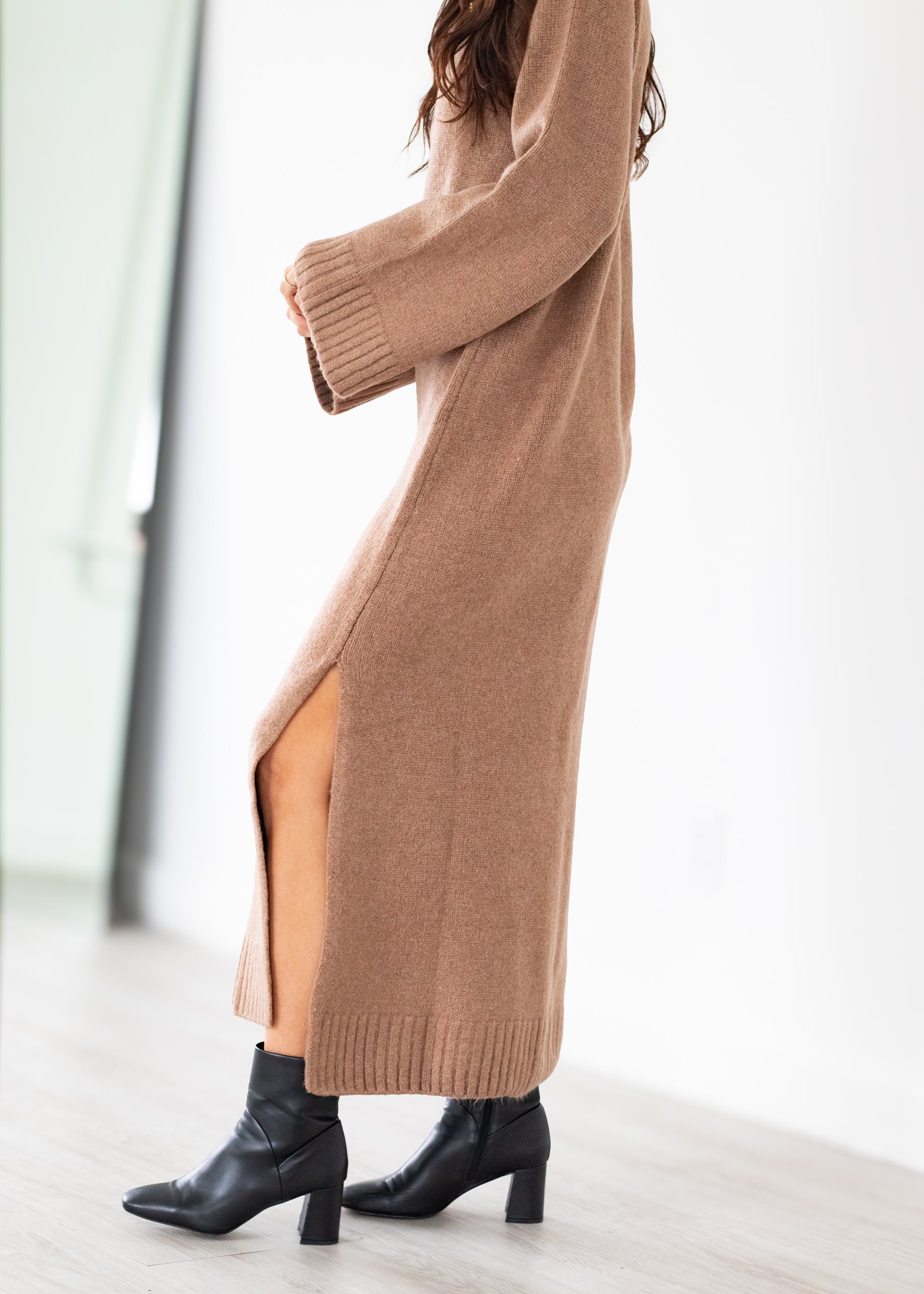 Long brown sweater maxi with a slit on a white background