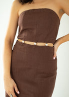 Brown strapless dress with a belt on a white background