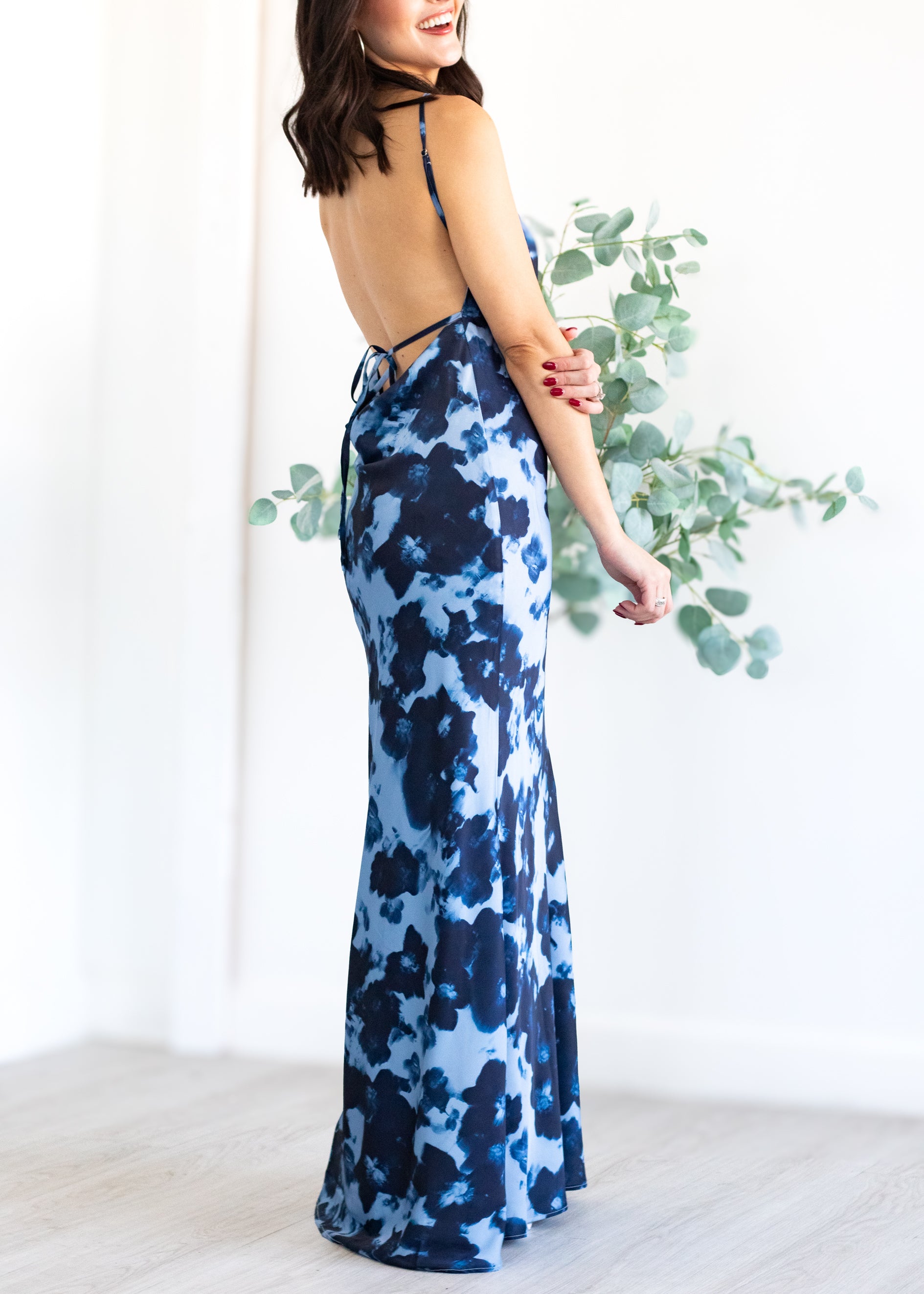 Woman wearing a blue floral dress with a white background