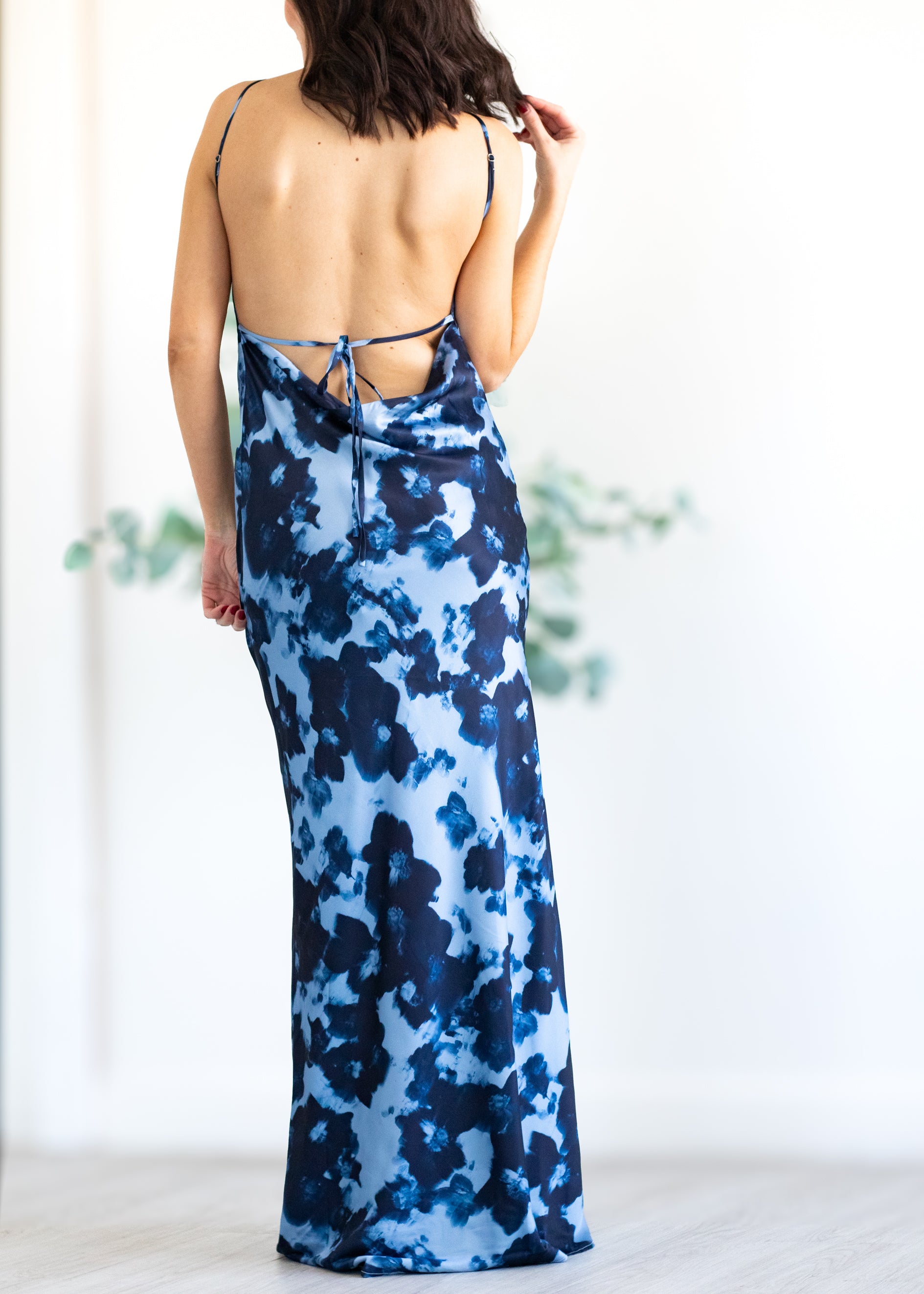 Woman wearing a blue floral dress with a white background