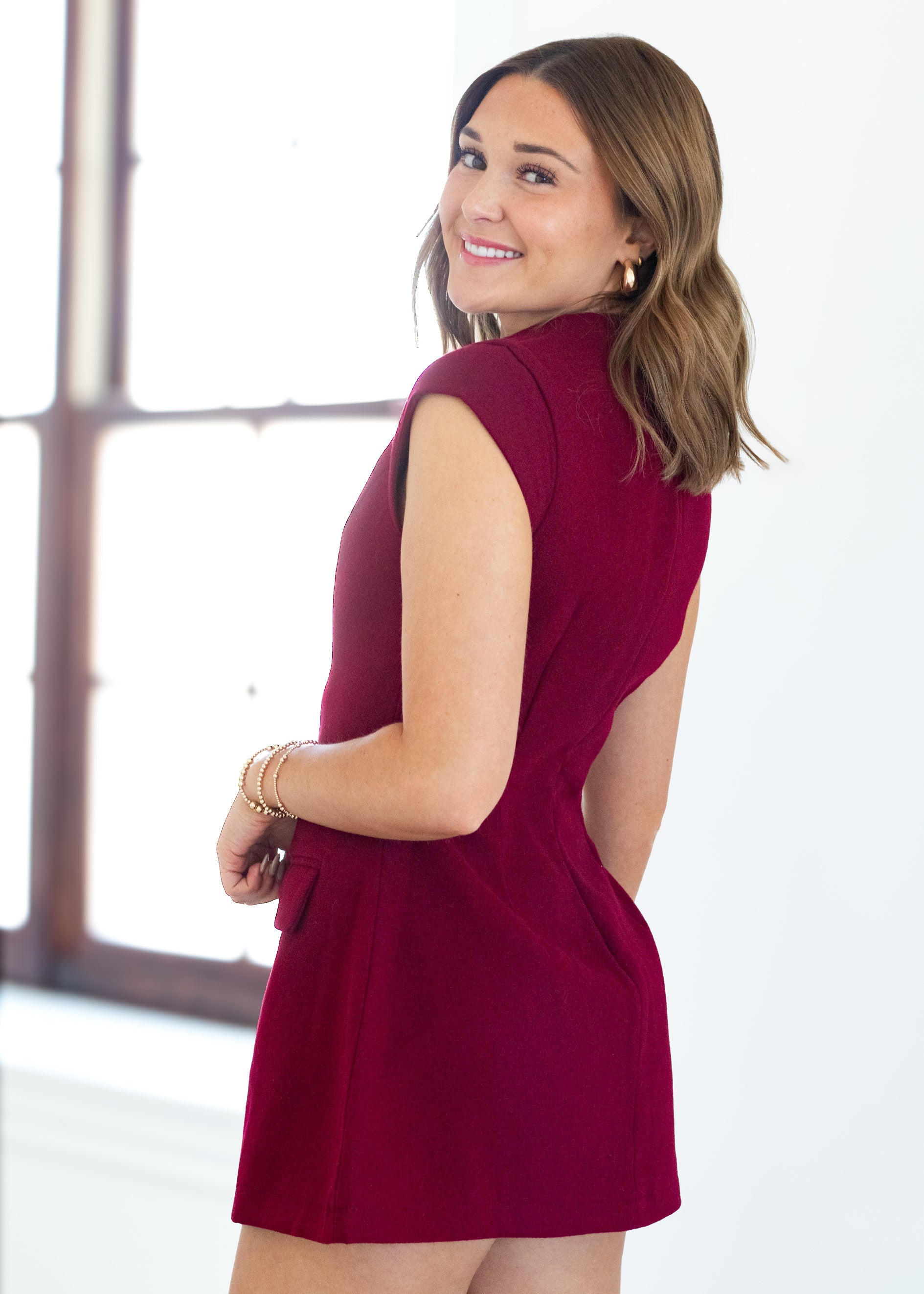 Woman wearing a red dress standing indoors.