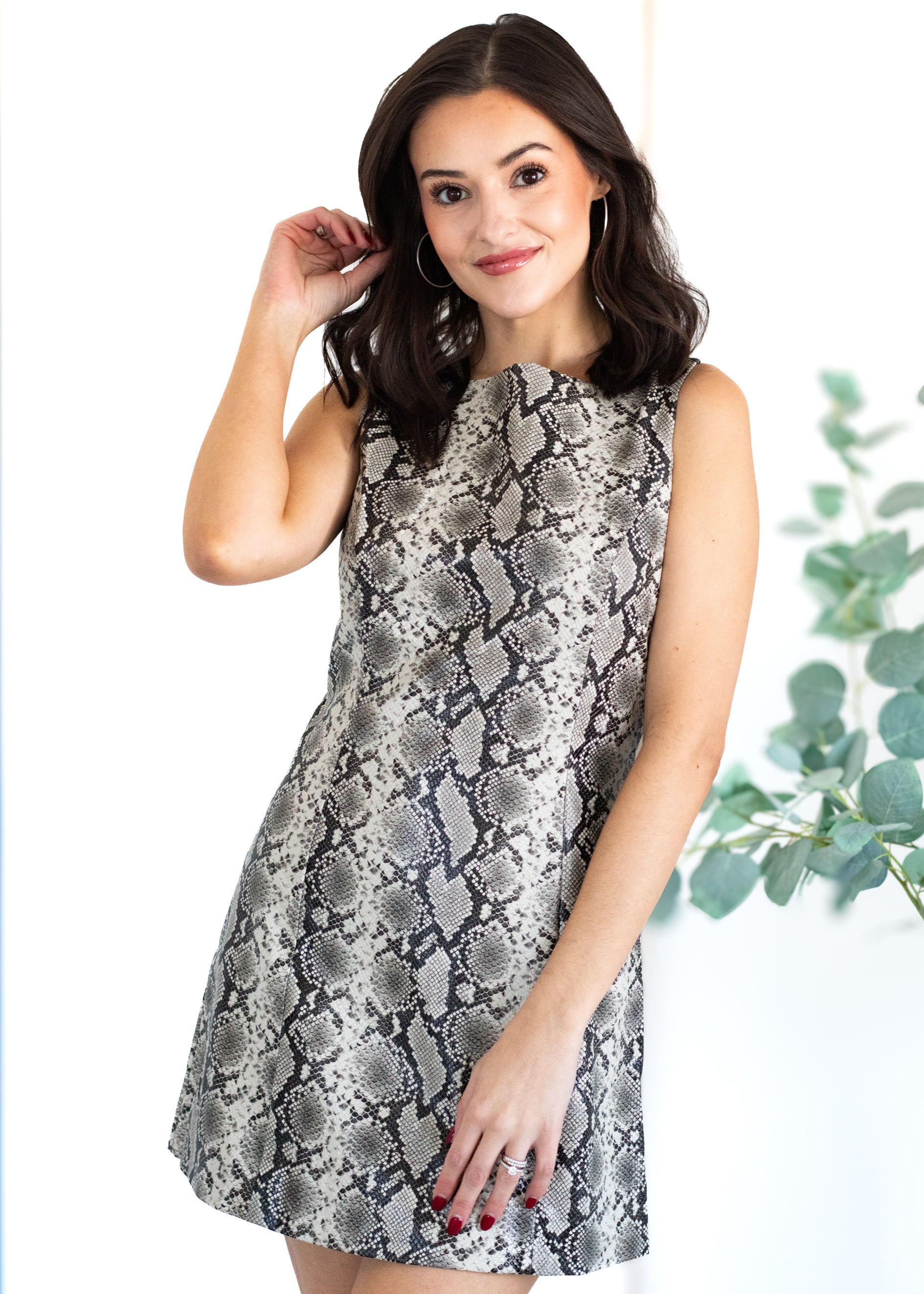 Woman wearing a patterned dress with a white background