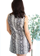 Person wearing a snake print dress with a blurred background