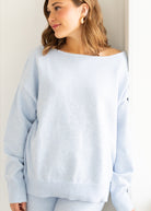 Woman wearing a light blue sweater against a plain background