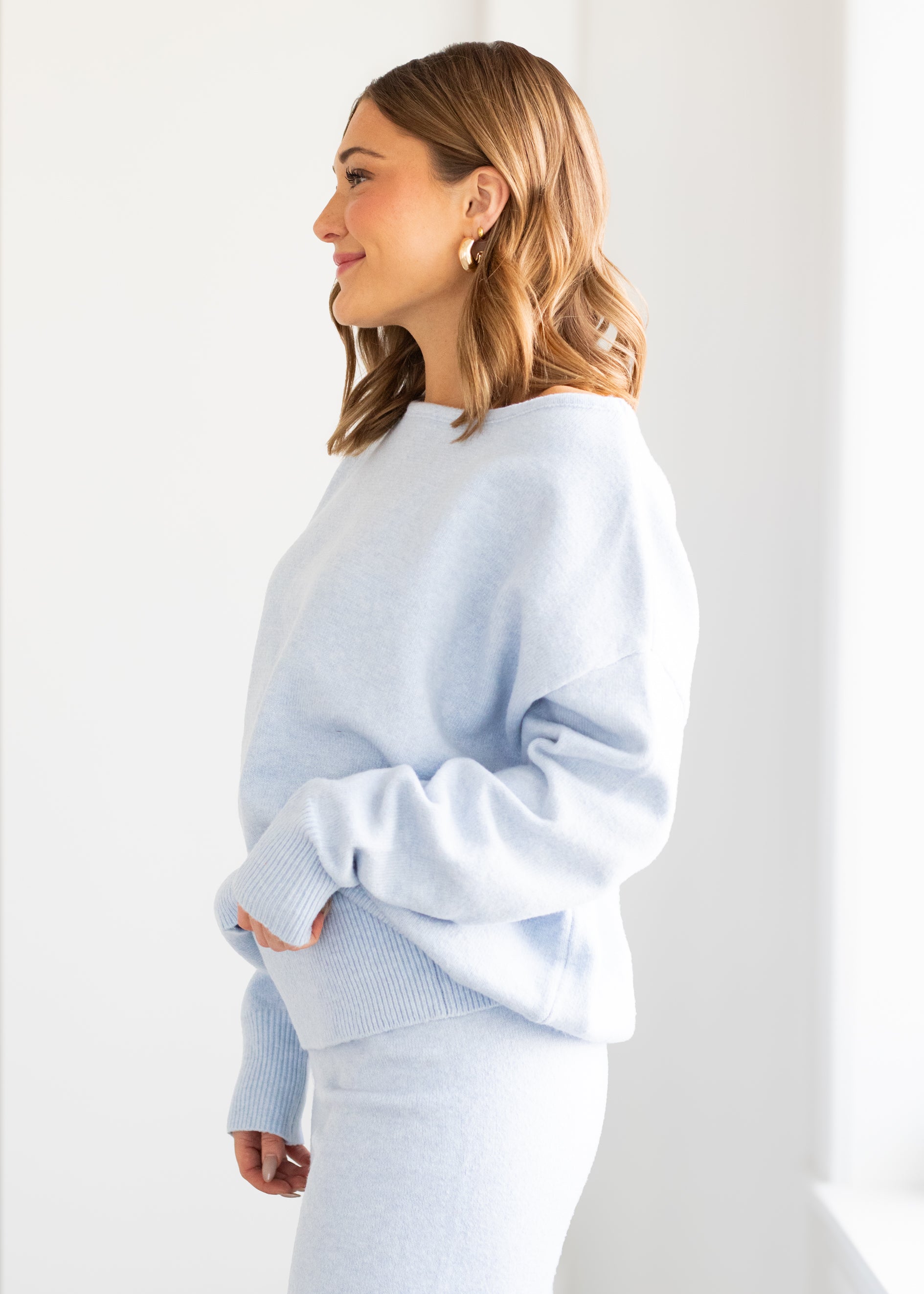 Woman wearing a light blue sweater against a white background