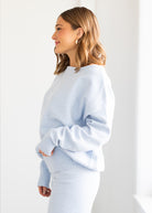 Woman wearing a light blue sweater against a white background