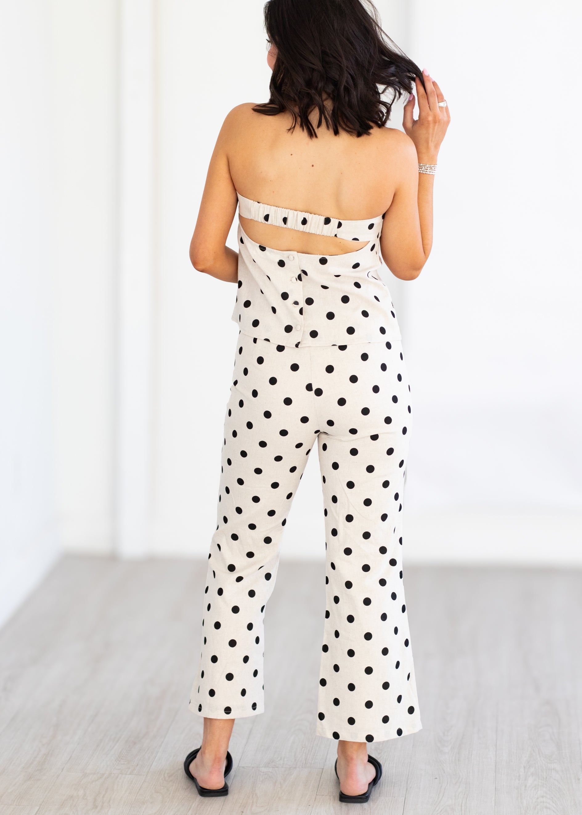 Woman wearing a polka dot matching set with a white background