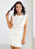 Woman wearing a white dress against a plain background
