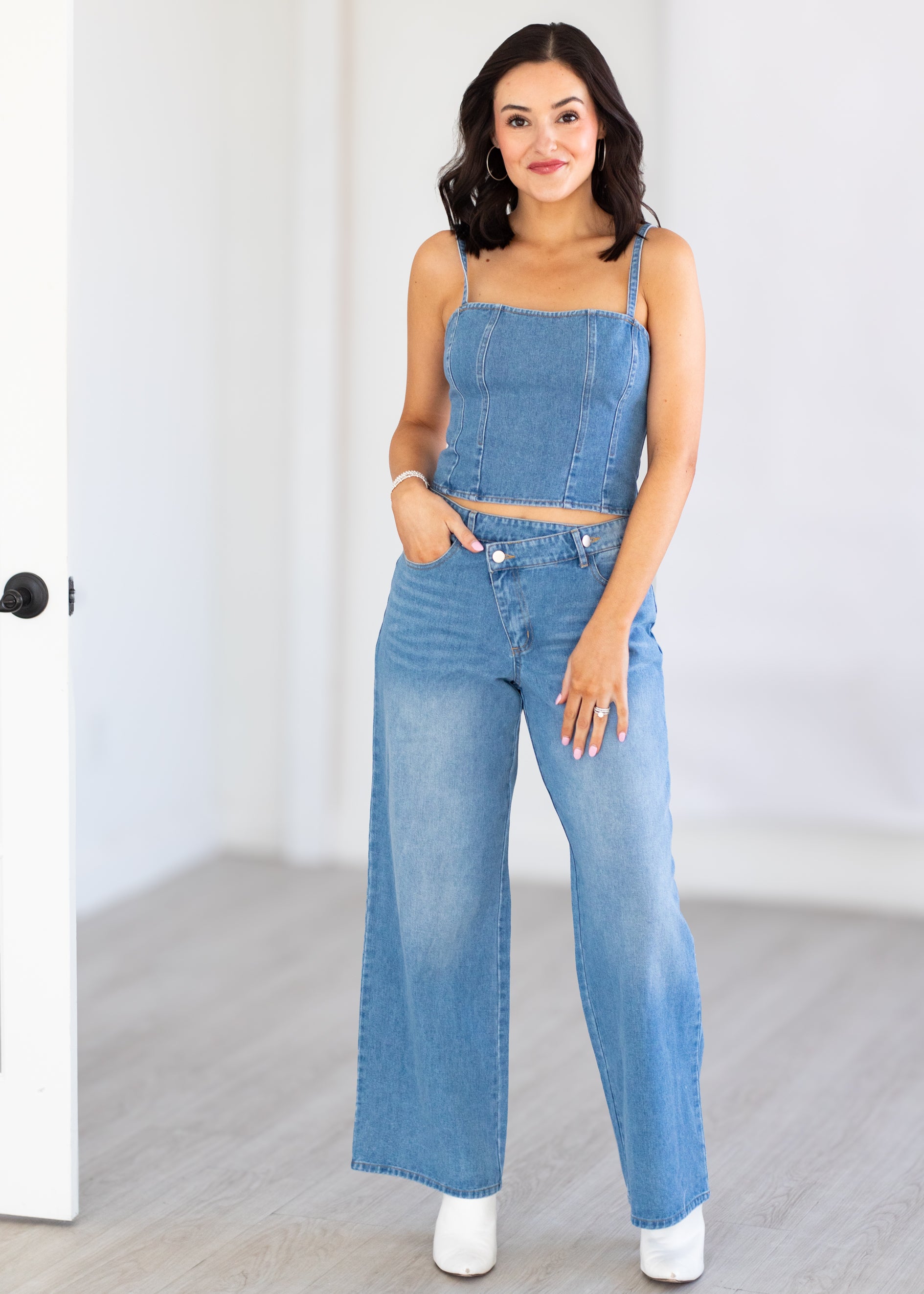 Woman wearing a denim matching set standing against a white background