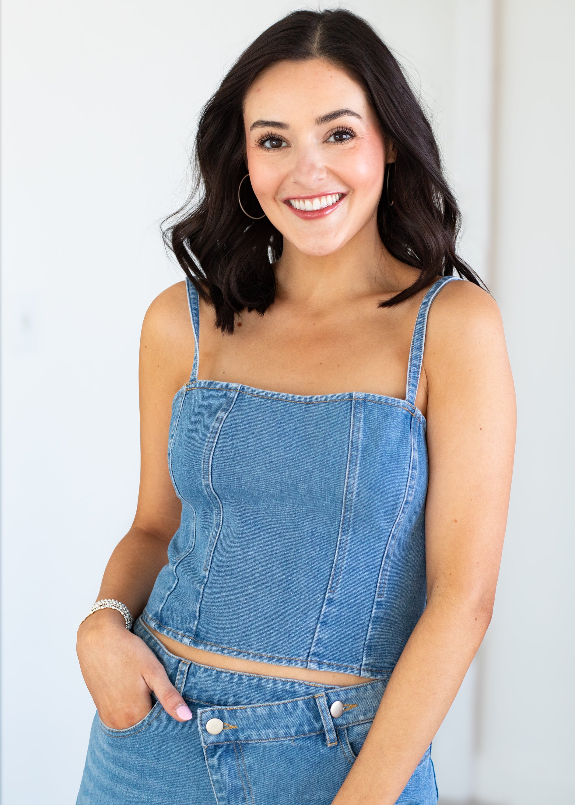 Woman wearing a blue denim matching  against a white background