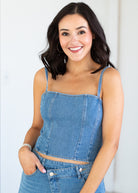 Woman wearing a blue denim matching  against a white background
