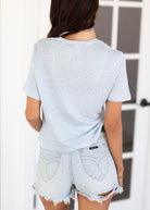 Person wearing a striped shirt and denim shorts with a blurred background