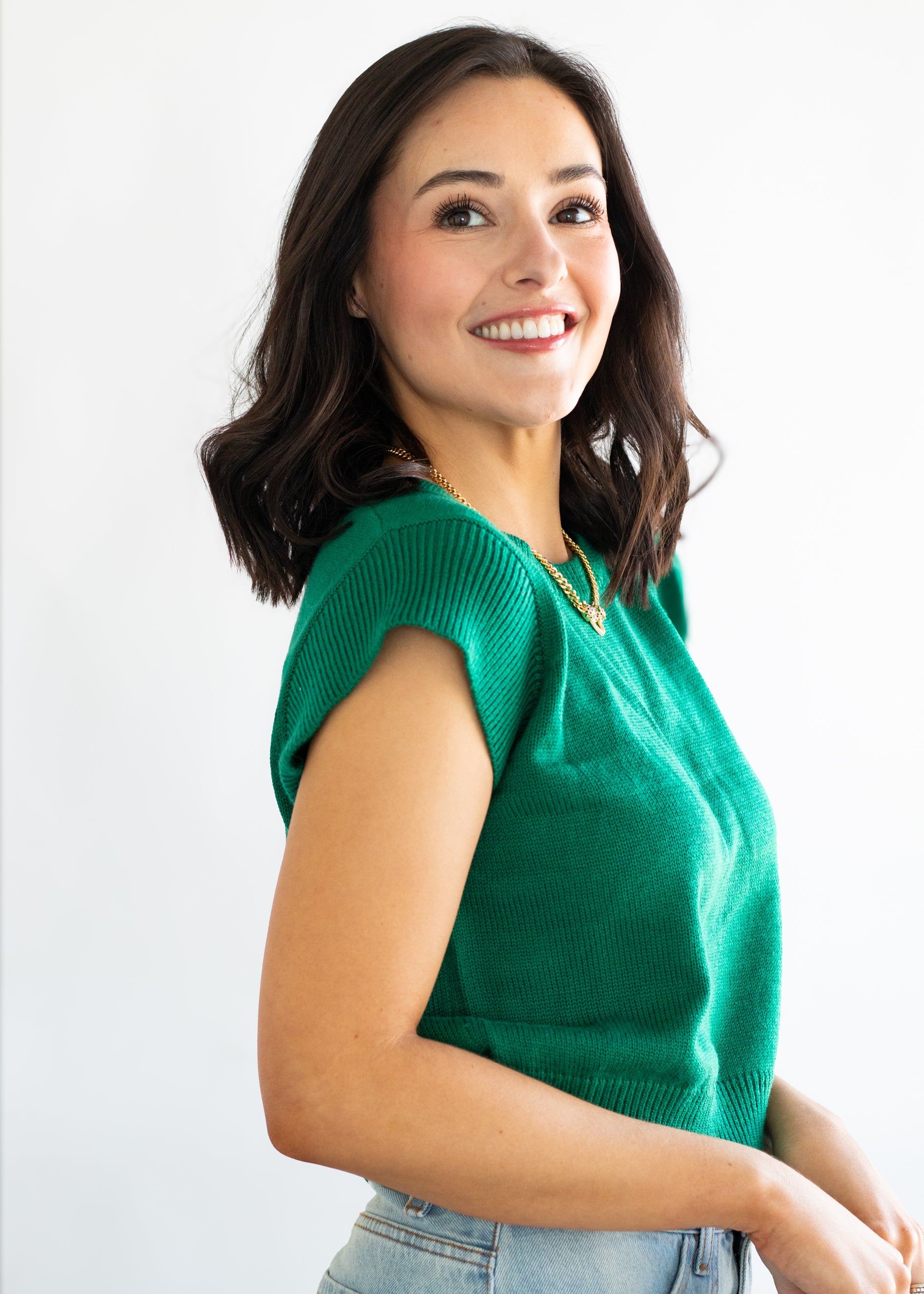 Woman wearing a green sweater against a white background