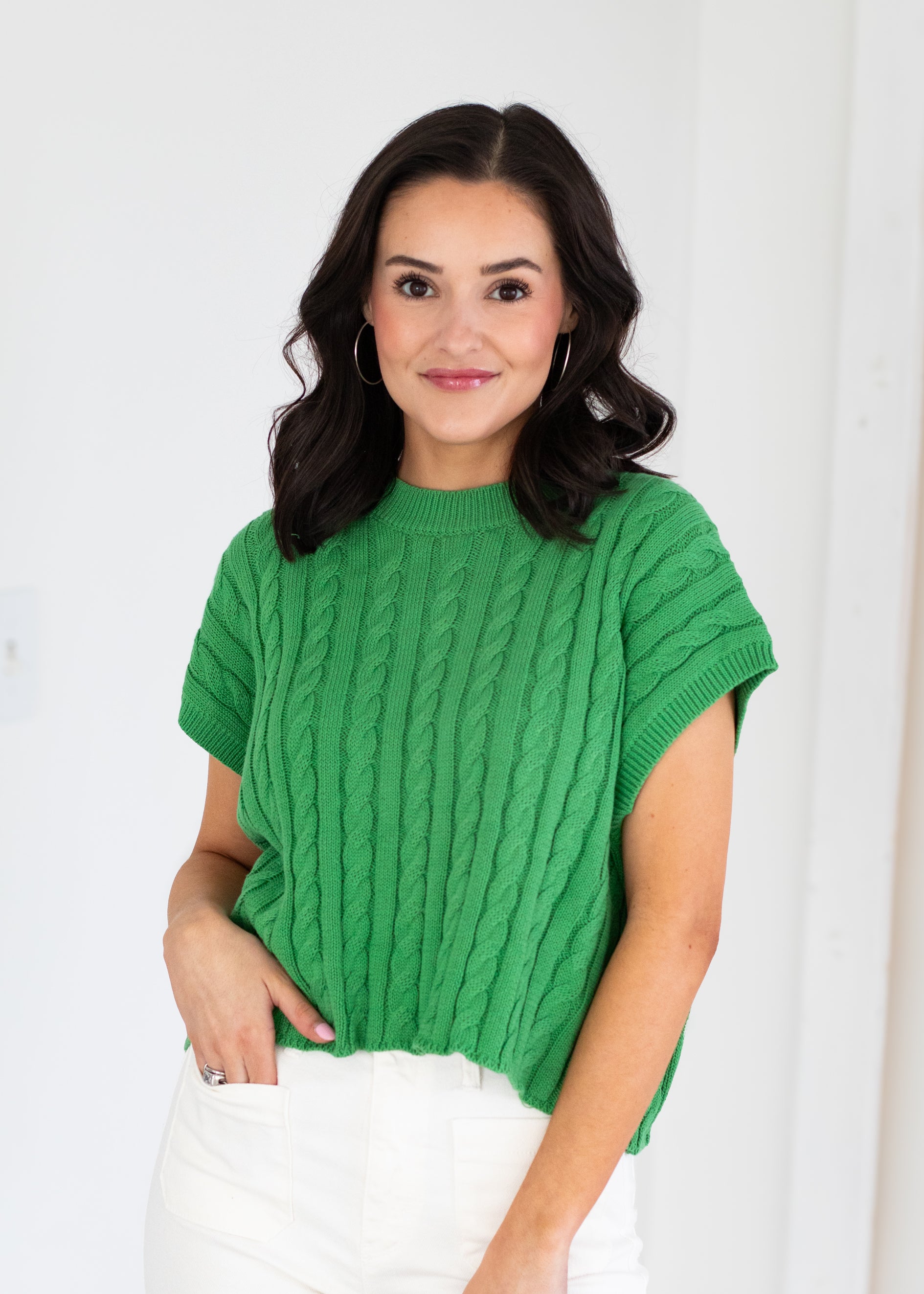 Woman wearing a green sweater against a white background