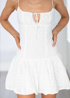 White dress with thin straps on a plain background
