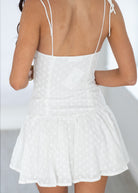 White dress with thin straps on a plain background