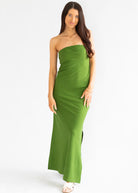Woman wearing a strapless green dress on a white background