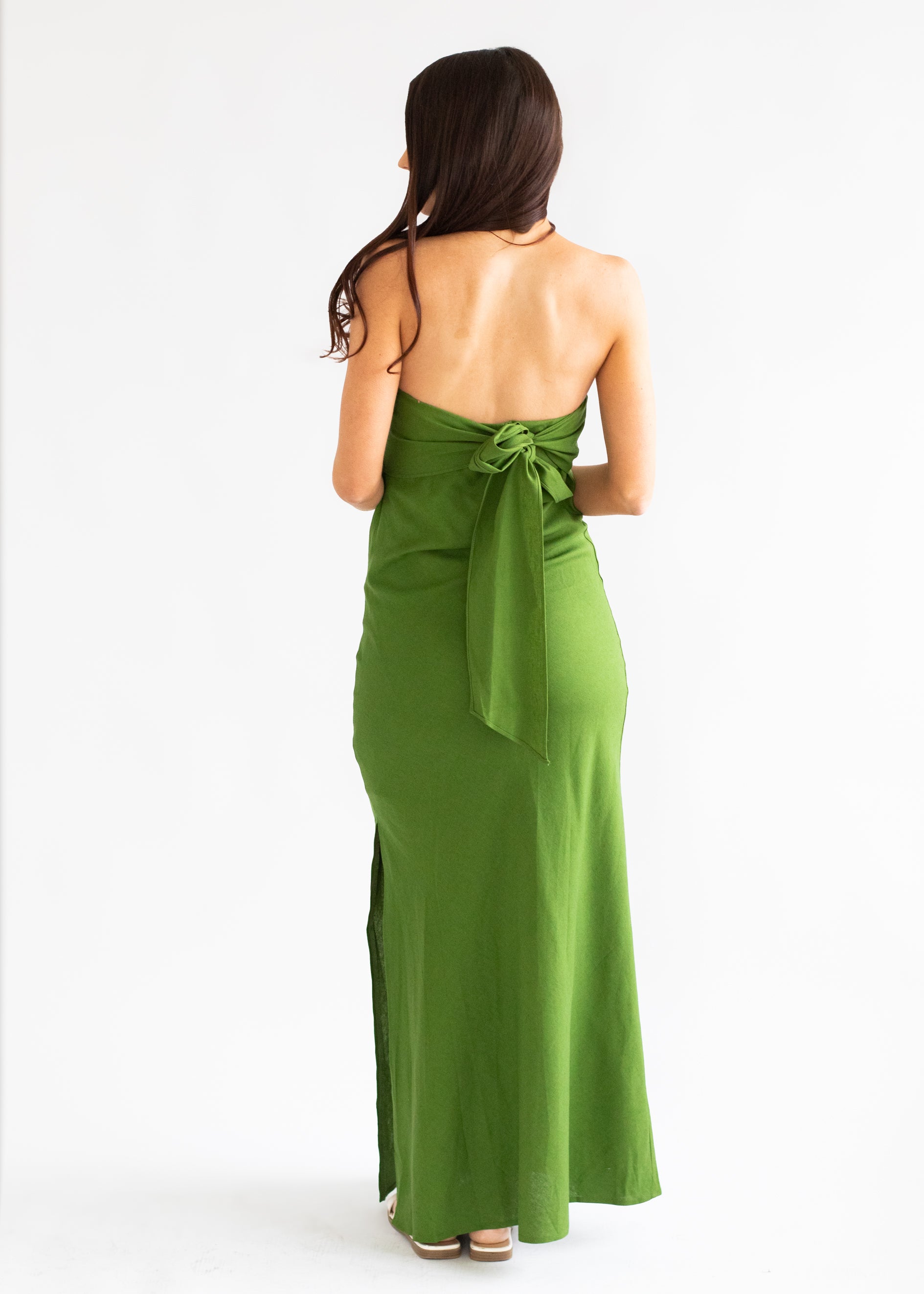 Green halter neck dress with a bow detail on a white background