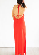 Woman wearing a red open-back dress on a white background