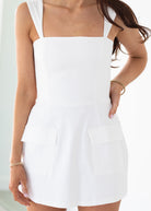 White dress worn by a person on a plain background