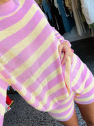 Person wearing a pink and yellow striped outfit in a store setting