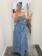 Person wearing a blue and white striped dress in a fitting room.
