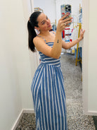 Woman taking a mirror selfie wearing a blue and white striped dress.