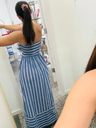 Woman wearing a blue and white striped dress in a store setting.